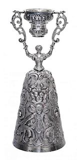 A German Silver Wager Cup, I.F. & Son Ltd., in the form of a maiden holding a swiveling cup aloft, her dress forming a larger cu