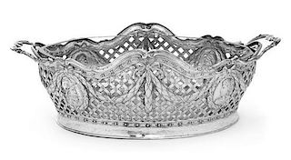 * A German Silver Basket, Likely Hanau Maker, 19th Century, having an openwork lattice decorated body with foliate and ribbon fe