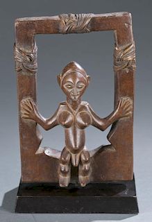 Seated hermaphroditic figure within an open frame.