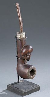 Wooden pipe with mounted human head.