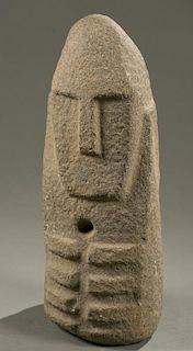 Stone obelisk with face, 20th century.