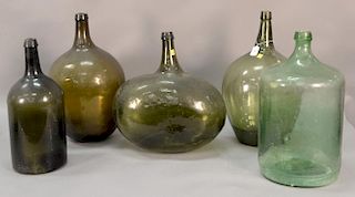 Five large early bottles, various forms and colors, including four olive green. ht. 18 1/2in. to 21 1/2in.
