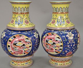Pair of famille rose two part vases having blue and yellow ground, hand painted scrolling flowers and vines, and three reticulated c...