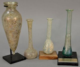Four Roman glass tall flasks including two candlestick flasks, a tear drop flask, spindle bottle on stand, and a Lentoid Aryballos. ...