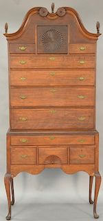 Queen Anne cherry high chest in two parts, upper section with closed bonnet top with two pinwheels over large center drawer with pin...