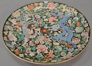 Chinese famille rose enameled 'mille fleur' design porcelain charger decorated with dragon and phoenix on black ground, late 19th/ea...