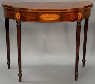 Sheraton mahogany games table having D shaped top over conforming frieze with maple panels, all set on turned and fluted legs, circa...