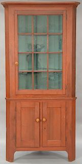 Corner cabinet in two parts, upper section with cornice molded top over single door with twelve glazed glass panels on lower section...