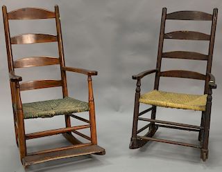 Two early ladder back rockers each with four slats and rush seats.