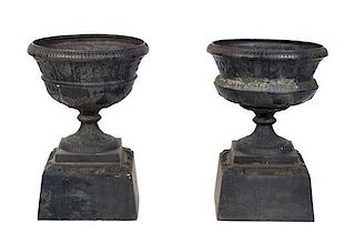 A Pair of Cast Iron Garden Urns Height 21 inches.