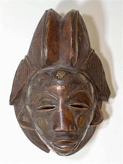* An African Carved Wood Mask, Ivory Coast Length 10 1/2 inches.