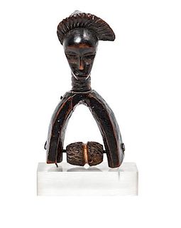 An African Carved Wood Stirrup, Height 6 1/2 x width 3 1/4 x depth 2 7/8 inches.