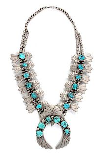 A Silver and Turquoise Squash Blossom Necklace Length of necklace 24 inches, naja height 3 1/2 x width 2 5/8 inches.