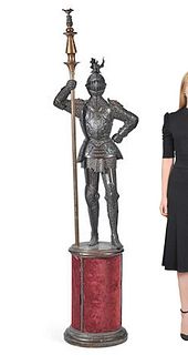 A PATINATED BRONZE FIGURE OF AN ARMOURED KNIGHT