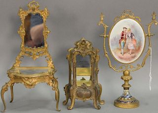 Three piece lot to include a brass enameled vanity mirror with porcelain painted plaque (12in.), small brass French style cabinet (8...