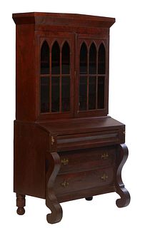 American Classical Gothic Carved Mahogany Secretary Bookcase, 19th c., the sloping crown over double mullioned Gothic arched glazed doors, on a base w