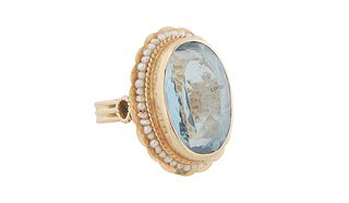 Lady's 14K Yellow Gold Dinner Ring, with a large app. 6 ct. oval blue topaz atop a scalloped border of tiny seed pearls, Size 6. Provenance: The Estat