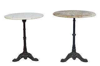 Two Parisian Marble Top Iron Bistro Tables, 20th c., the circular white marble on an iron reeded support to tripodal paw feet on one example; the othe