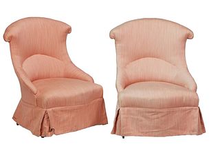 Pair of French Louis XV Style Carved Walnut Bergeres, 20th c., the arched curved back over a cushioned seat, in pink fabric, with a long dust ruffle, 