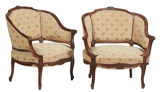 Pair of French Louis XV Style Carved Walnut Bergeres, early 20th c., the arched curved floral carved crest rail over an upholstered barrel back flanke