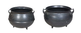 Two American Cast Iron Kettles, 19th c., with ring handles on tripodal legs, one marked Baltimore, H.- 14 3/4 in., Dia.- 21 in., and H.- 15 1/2 in., D