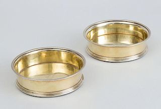PAIR OF GEORGE III CRESTED SILVER-GILT BOTTLE COASTERS