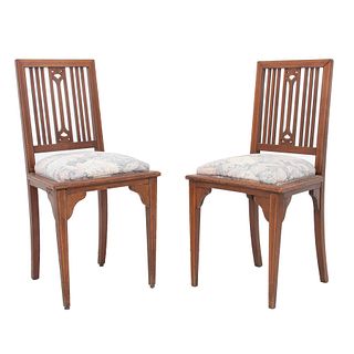 PAR DE SILLAS. SXX. Elaboradas en madera. Respaldo con barandillas, asiento acojinado y soportes lisos. Decorada con elementos florales