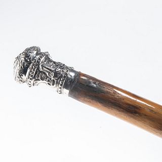 A CARVED BAMBOO CANE WITH SILVER TOP