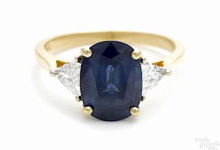 18K yellow gold, sapphire, and diamond ring with an oval cut central blue sapphire, 3.10ct