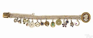 14K yellow gold charm bracelet with a cameo clasp and fourteen charms, to include two opal