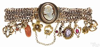 14K yellow gold charm bracelet, with a cameo clasp and 11 charms, 7'' l., 21.5 dwt.