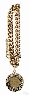 14K yellow gold chain link bracelet, 7'' l., with a monogrammed charm, 1'' dia., 18.5 dwt.