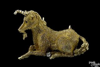 18K yellow gold reclining unicorn brooch with a ruby eye and a diamond accent, 1 7/8'' l., 13.4 dwt