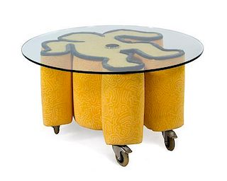 * A Keith Haring Glass Top Low Table, by Bretz, CIRCA 1998, with a circular glass top and an iconic Keith Haring sculptural f