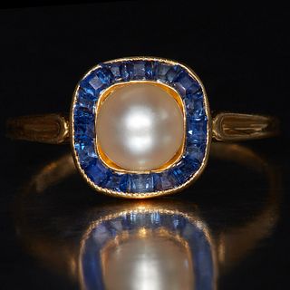 PEARL AND SAPPHIRE CLUSTER RING, set to the center with a pearl, flanked with calibre cut blue sapphires. Size. L 1/2. 2 grams.