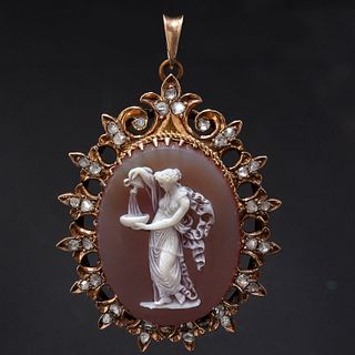 HARDSTONE CAMEO AND DIAMOND PENDANT, The oval carved hardstone cameo depicting a standing woman pouring water from an ewer into a bowl. The surmount o