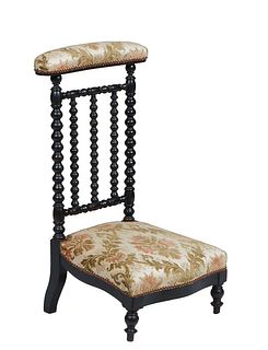 French Ebonized Beech Prie Dieu, 19th c., the arched cushioned armrest on bobbin turned supports, to a trapezoidal bowed seat, on turned tapered legs,