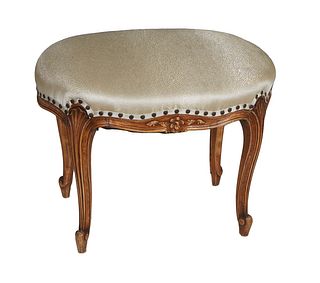 Louis XV Style Carved Beech Upholstered Footstool, 20th c., the oval top over a floral carved skirt, on scrolled reeded cabriole legs with toupie feet
