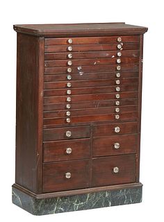 American Carved Mahogany Dental Cabinet, early 20th c., with twelve shallow drawers over six deep drawers, on a figured green marble base, H.- 43 3/8 