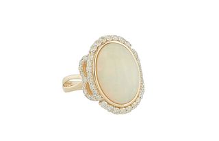 14K Yellow Gold Dinner Ring, with a cabochon oval 6.03 ct. opal, atop a conforming border flanked by diamond mounted mask lugs, over the split shoulde