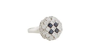 Lady's Platinum Dinner Ring, the sloping round top mounted with four central dark blue round sapphires, flanked by small round diamond borders, total 