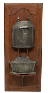 French Provincial Lavabo, 19th c., with a lead covered reservoir, with brass spigot to a lead bowl, mounted on a walnut backboard, H.- 56 in., W.- 24 