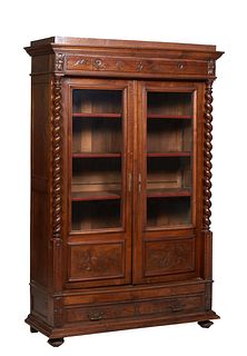 French Louis Philippe Carved Walnut Bookcase, 19th c., the stepped ogee crown over an incised frieze above set back double doors with glazed upper pan