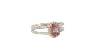 Lady's Platinum Dinner Ring, with an oval 1.63 ct. pink sapphire, atop a border of tiny round diamonds, the split shoulders of the band also mounted w