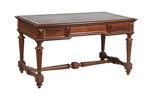 French Henri II Style Carved Walnut Desk, late 19th c., the stepped rounded edge top with an inset gilt tooled leather writing surface over three setb