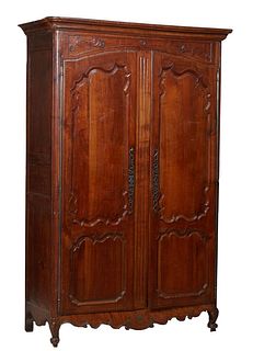 French Louis XV Style Carved Walnut Armoire, early 19th c., the stepped rounded edge corner over a floral carved frieze and arched double two panel do