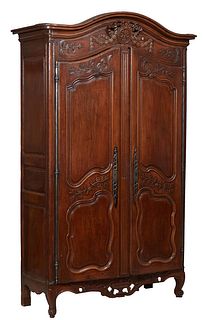 French Provincial Louis XV Style Carved Walnut Armoire, 19th c., the arched stepped rounded corner crown over a relief carved garland and floral friez