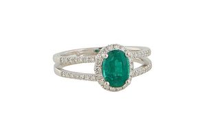 Lady's 18K White Gold Dinner Ring, with an oval 1.04 emerald atop a border of tiny round diamonds, the split shoulders of the band also mounted with t
