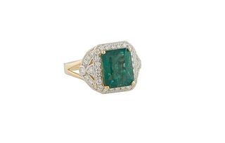 Lady's 18K Yellow Gold Dinner Ring, with a 3.52 ct emerald, atop an octagonal border of small round diamonds, within split diamond mounted lugs and sp