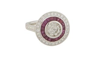 Lady's Platinum Dinner Ring, with a central round 1.02 ct. diamond, within a border of ruby baguettes, and an outer border of small round diamonds, th